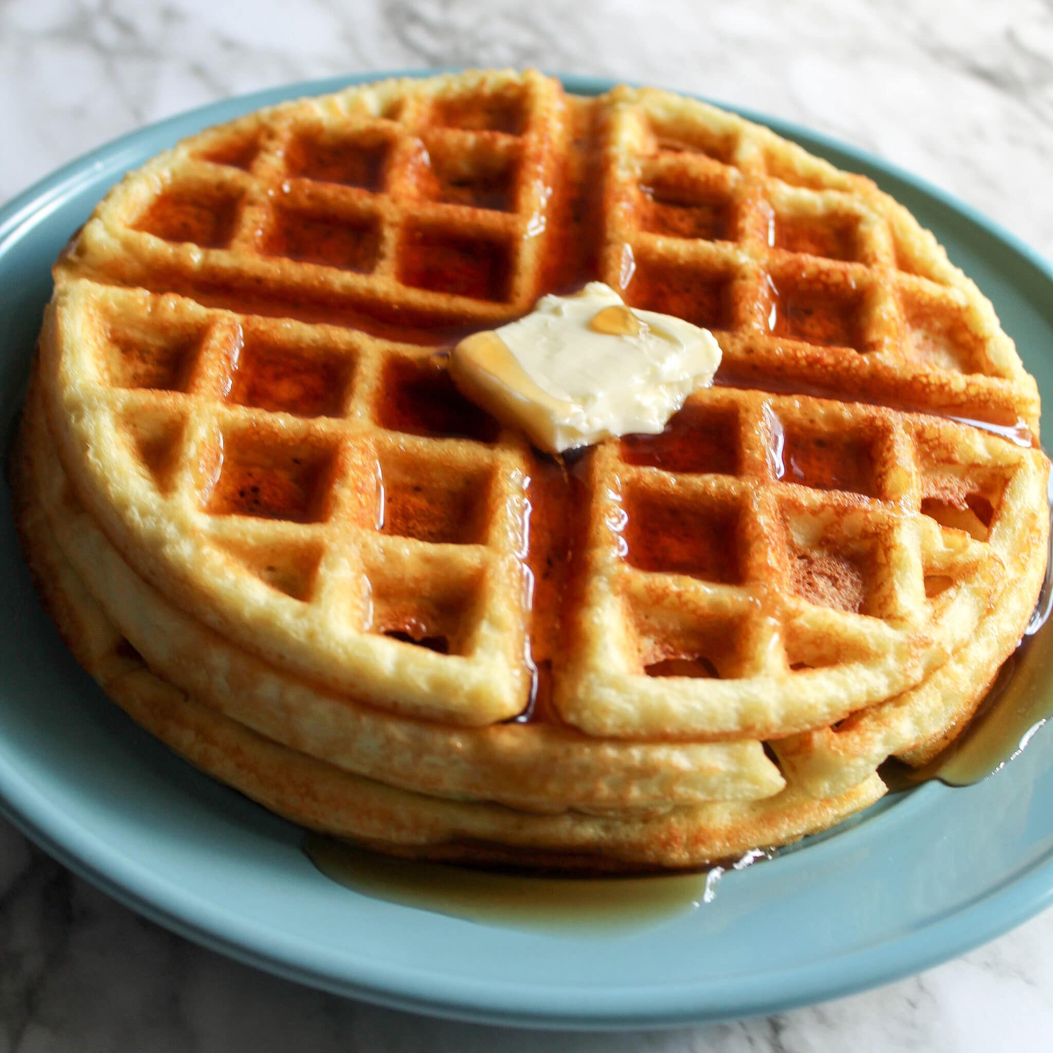 overhead shot of keto waffles topped with butter and syrup.