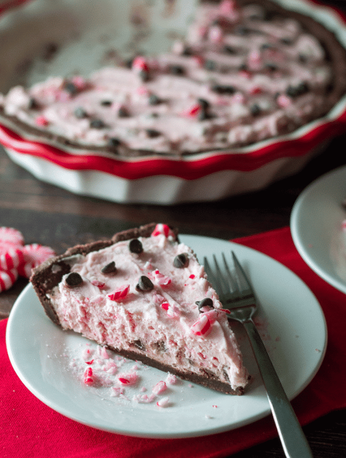 Keto Candy Cane Pie sliced on a white plate with the remaining pie in the background.