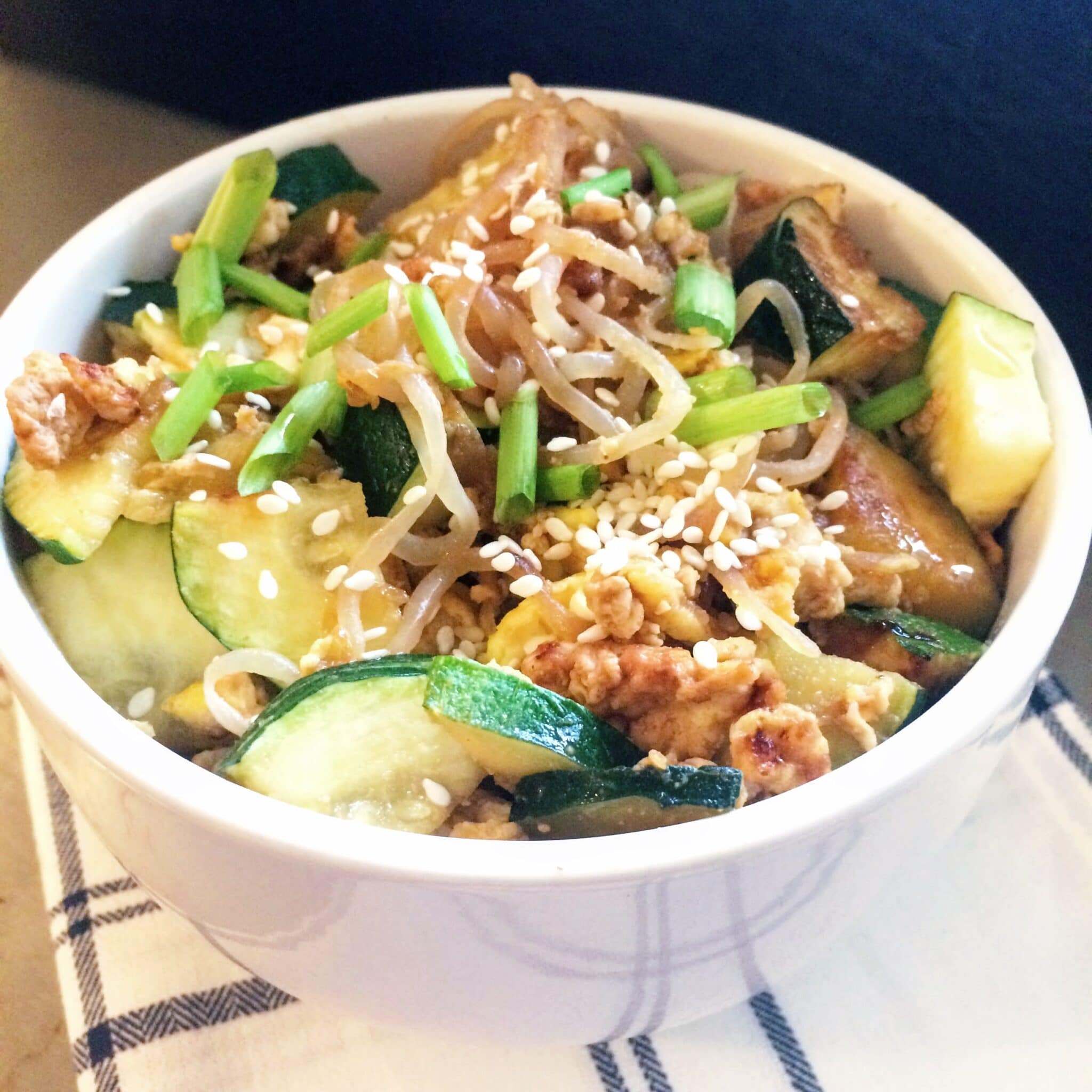 A white bowl full of konjac noodles and vegetables