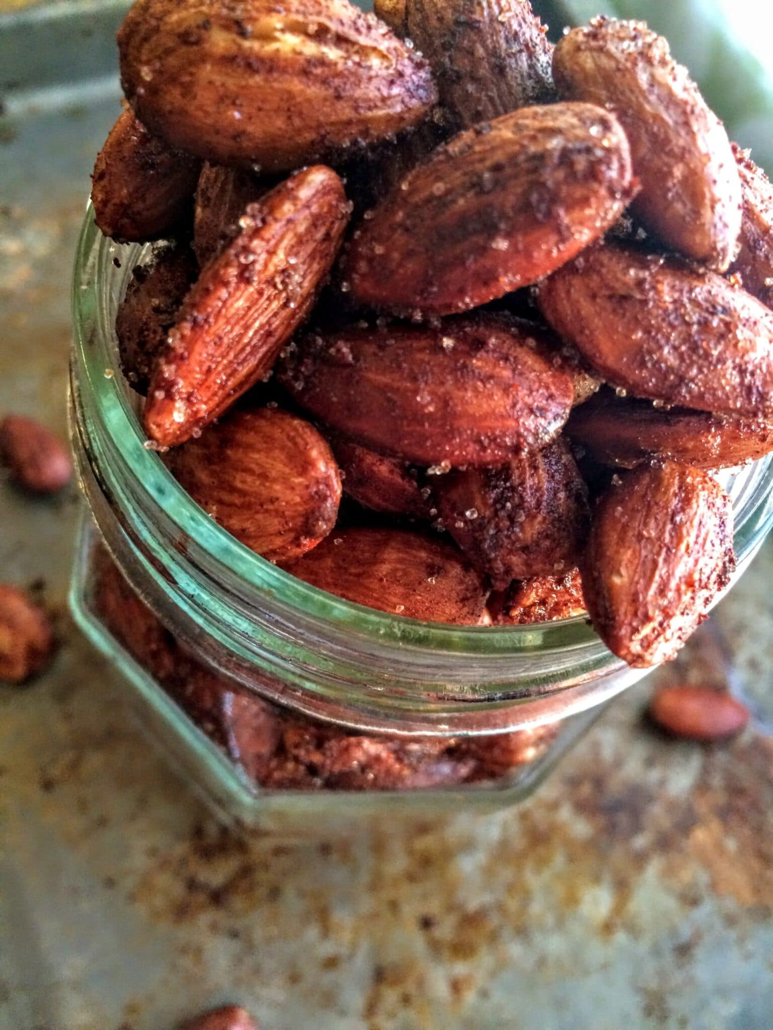 a glass jar full of cinnamon roasted almonds