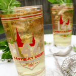two mint juleps in Kentucky derby glasses