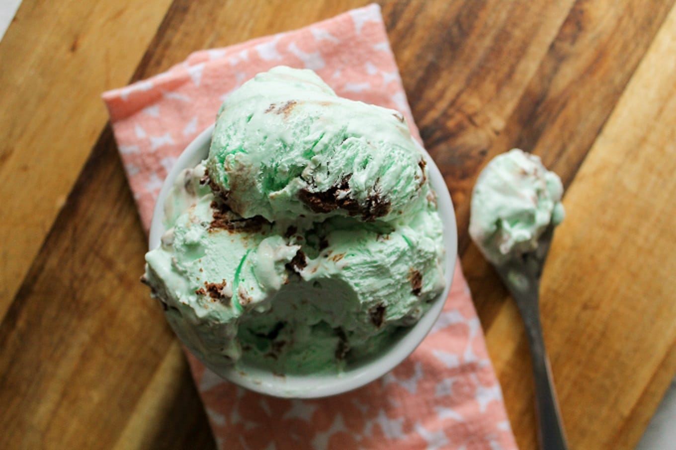 an overhead image of green mint chip ice cream with a spoon on the side