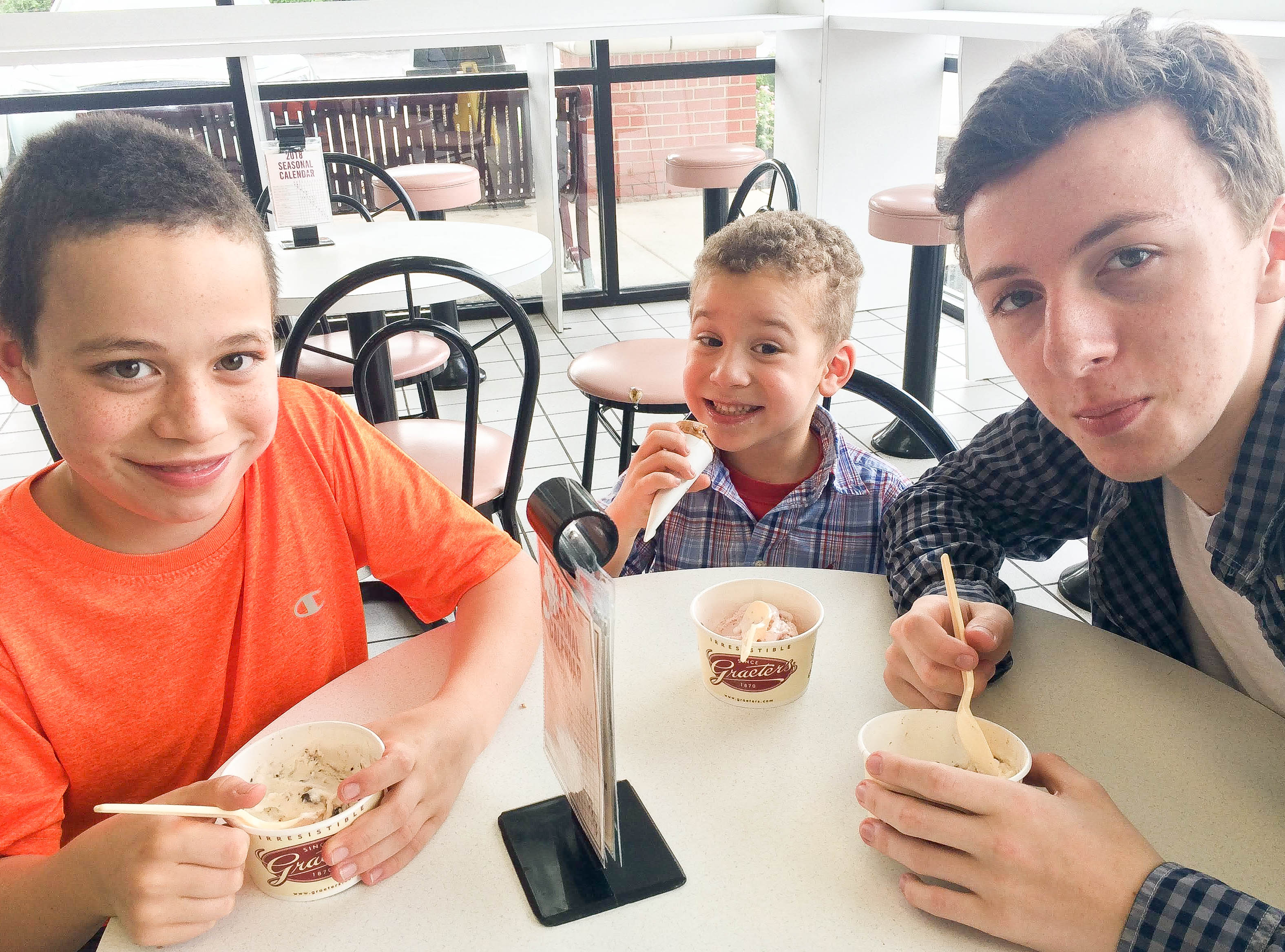 My 3 boys, ages 14, 10 and 3, sitting around a small table eating ice cream