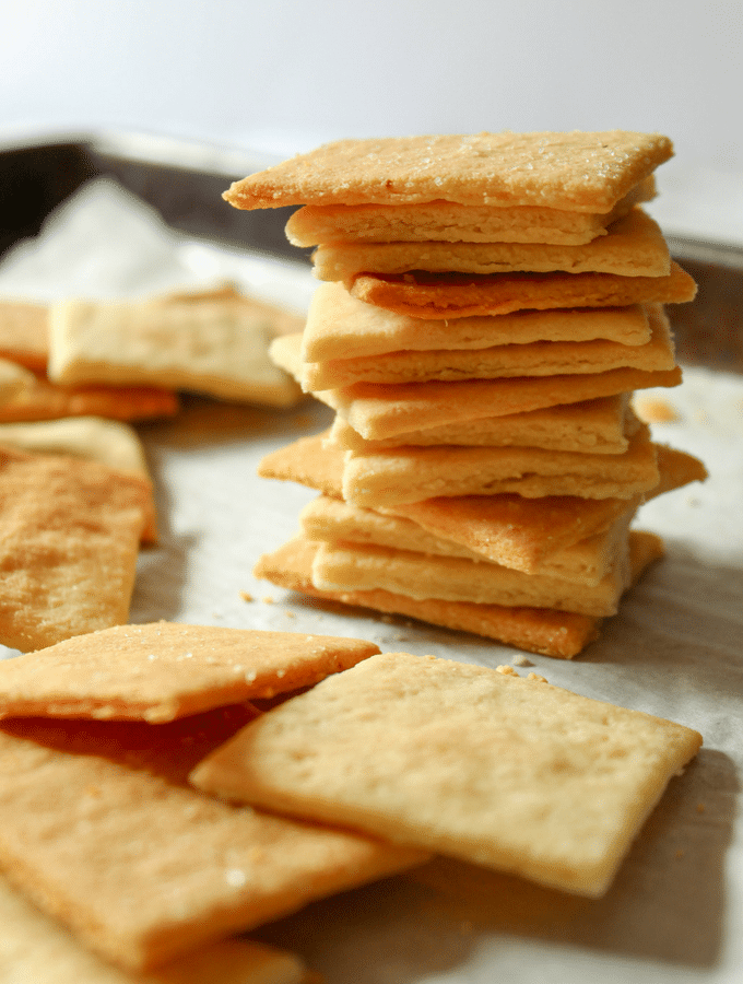 Parchment paper with scattered square crackers and one tall stack of crackers