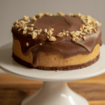 Keto chocolate peanut butter cheesecake on white cake stand
