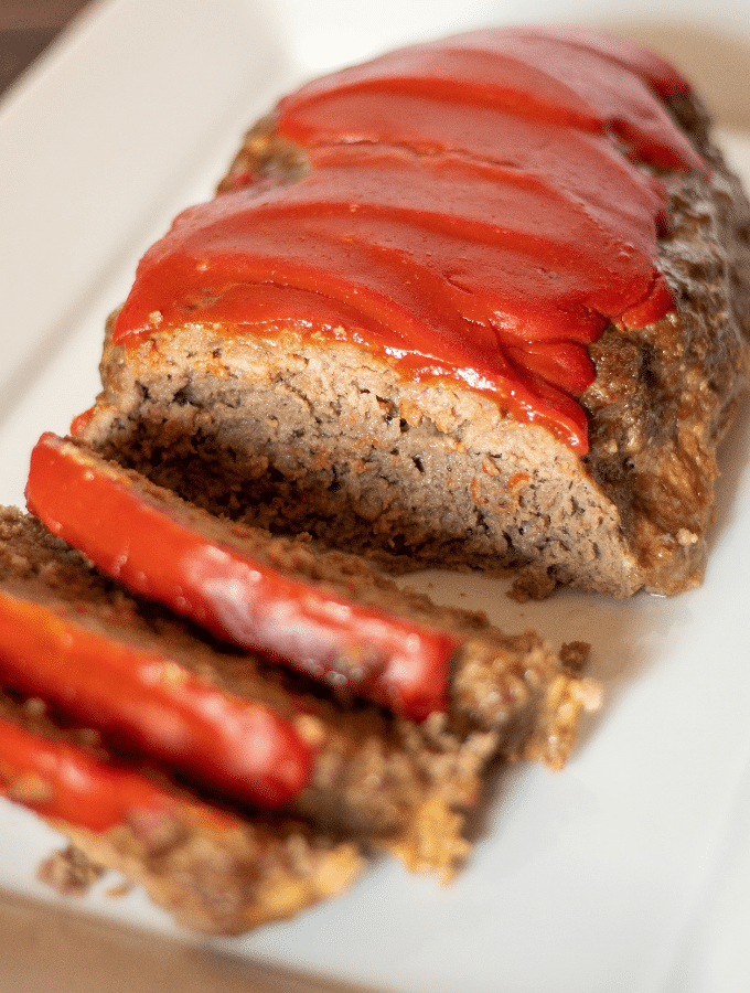 keto southern style meatloaf, topped with ketchup sliced on a white platter