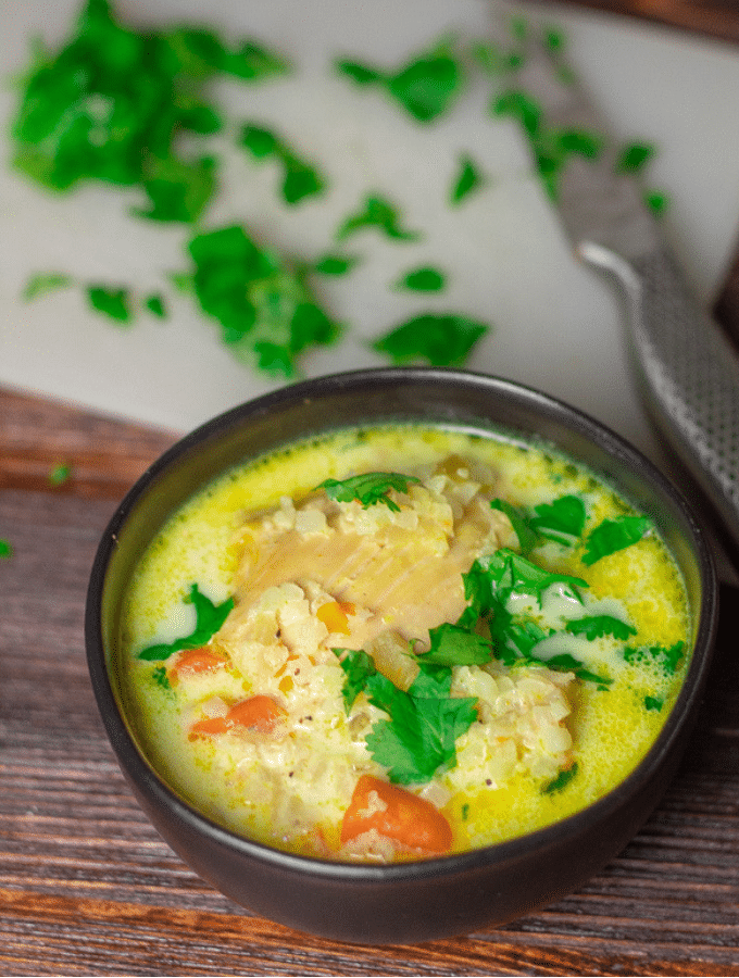 Keto Chicken Mulligatawny Soup in a small black bowl, topped with cilantro