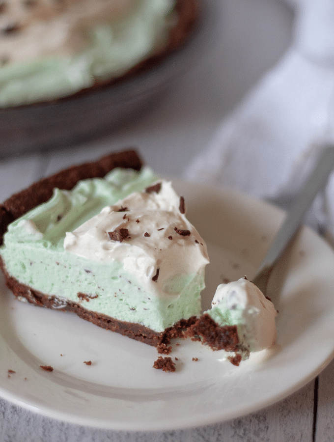 low carb frozen mint chocolate chip pie sliced on a plate with one bite taken