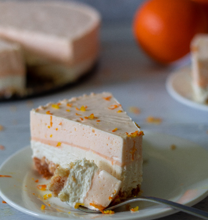 keto orange creamsicle cheesecake sliced and topped with orange zest