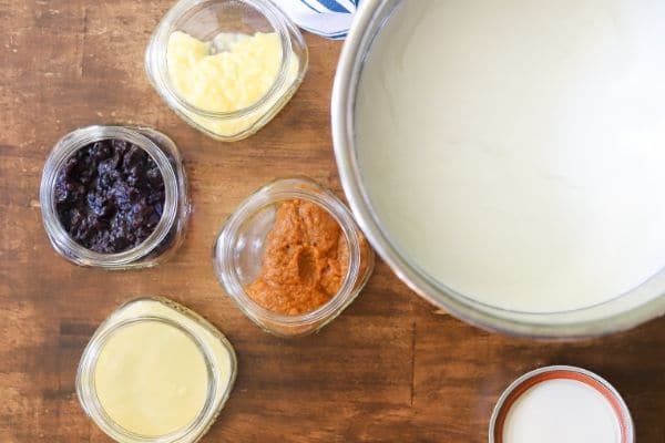 An instant pot full of homemade low carb yogurt with four small jars of fruit off to the side