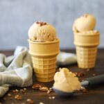 two ceramic ice cream cones filled with scoops of keto pumpkin ice cream