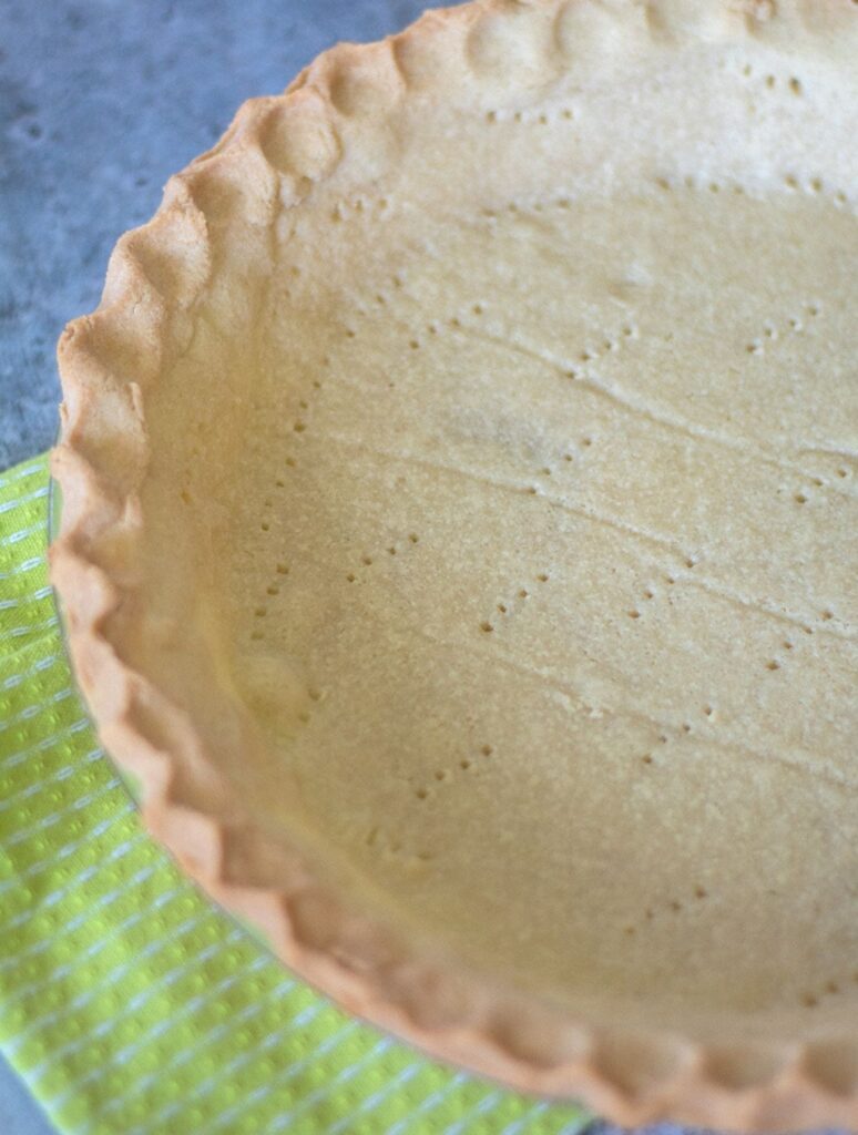 An empty keto friendly pie crust sitting on a green towel