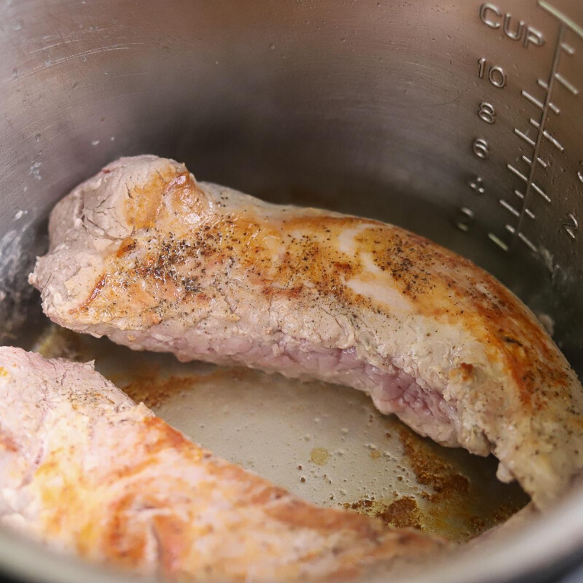 a pork tenderloin being seared inside of an instant pot
