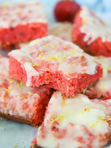 a stack of low carb strawberry lemon bars on a parchment lined platter