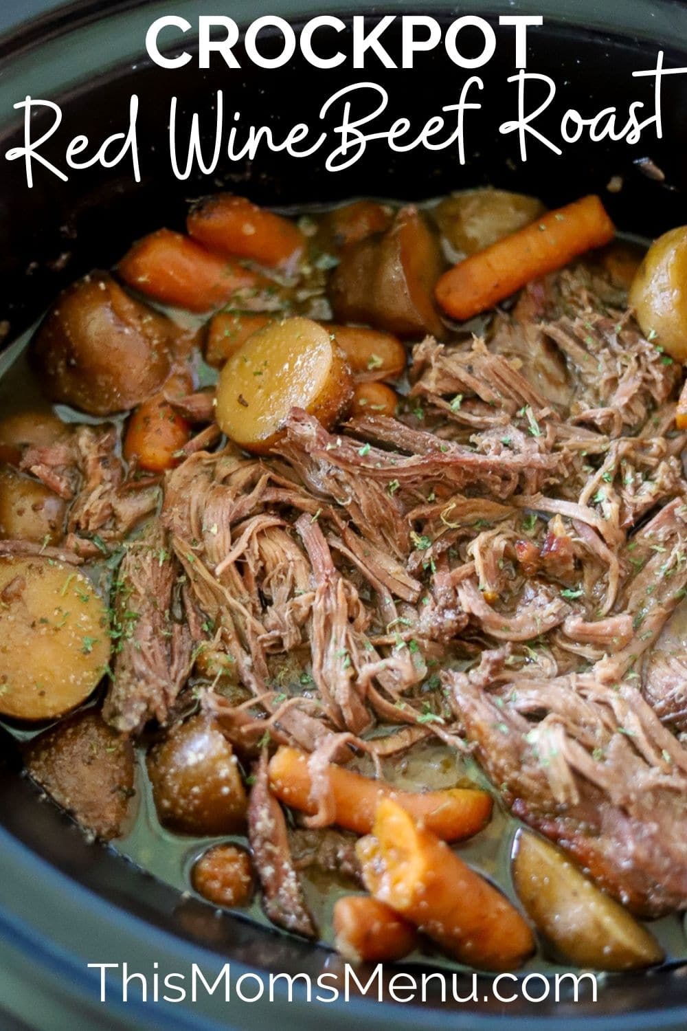 A black crockpot full of red wine beef roast with carrots and potatoes, there is a white text overlay with the title of the recipe.  