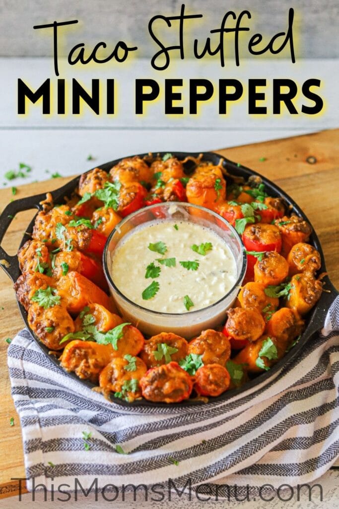 mini taco stuffed peppers in a cast iron skillet with a bowl of queso dip in the center and a text overlay with the recipe title