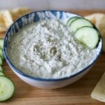 homemade Tzatziki sauce in a bowl with cucumber slices for dipping
