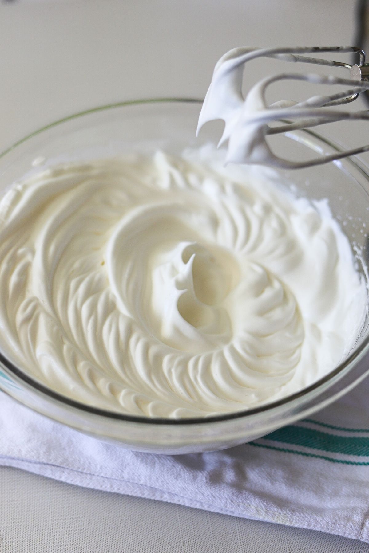 Egg whites in a glass bowl, beaten to stiff peaks