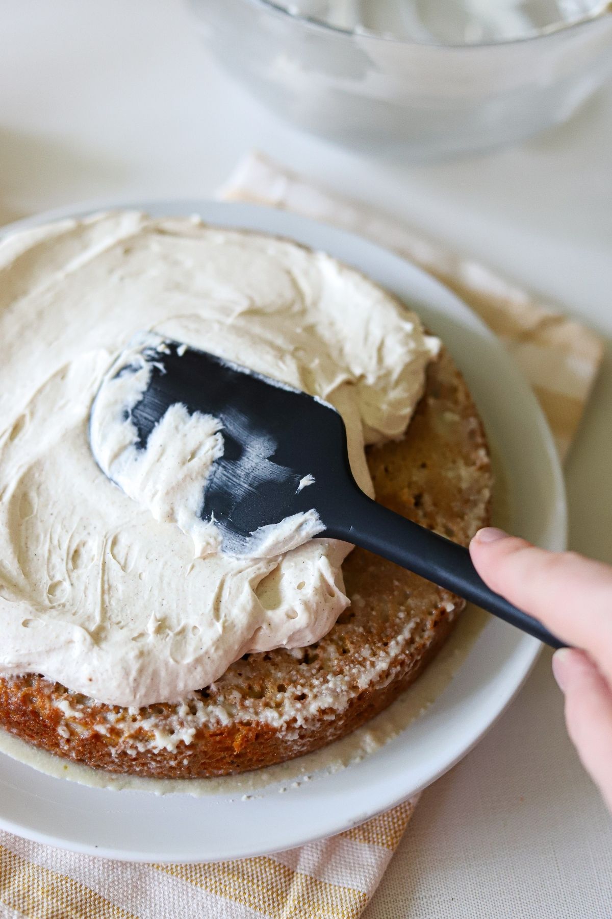 Whipped cream being spread over a pumpkin tres leches cake