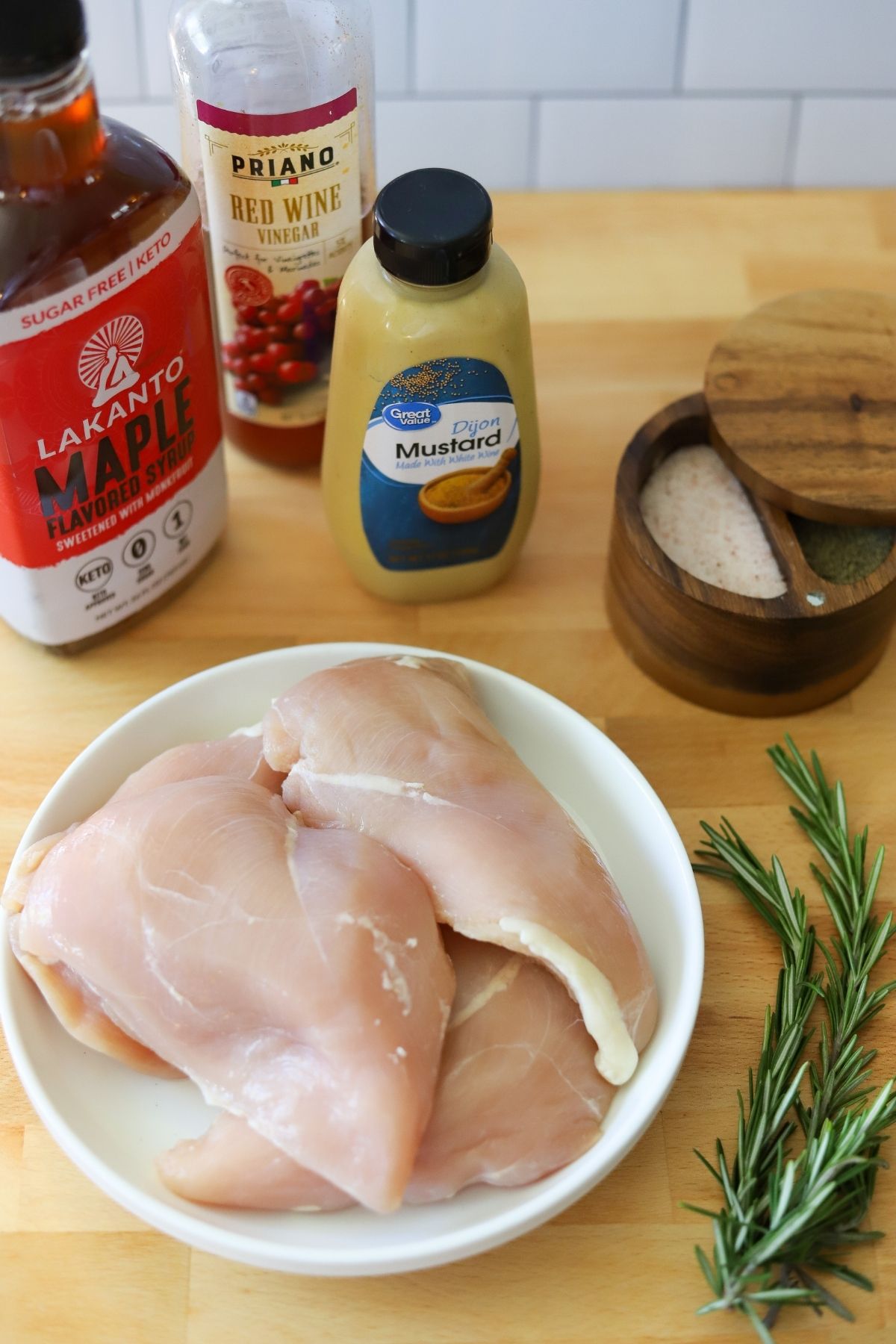 ingredients for maple dijon chicken breasts including chicken breast, sugar free maple syrup, red wine vinegar, dijon mustard, fresh rosemary, and salt and pepper