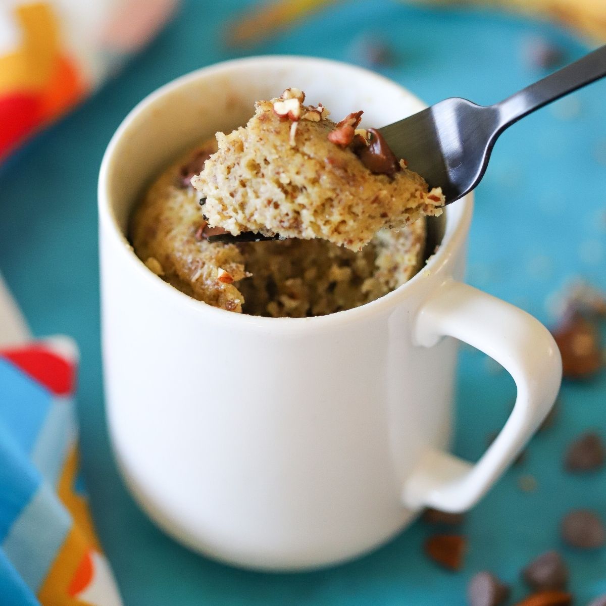 low carb banana cake cooked in a mug with one bite being lifted with a fork.