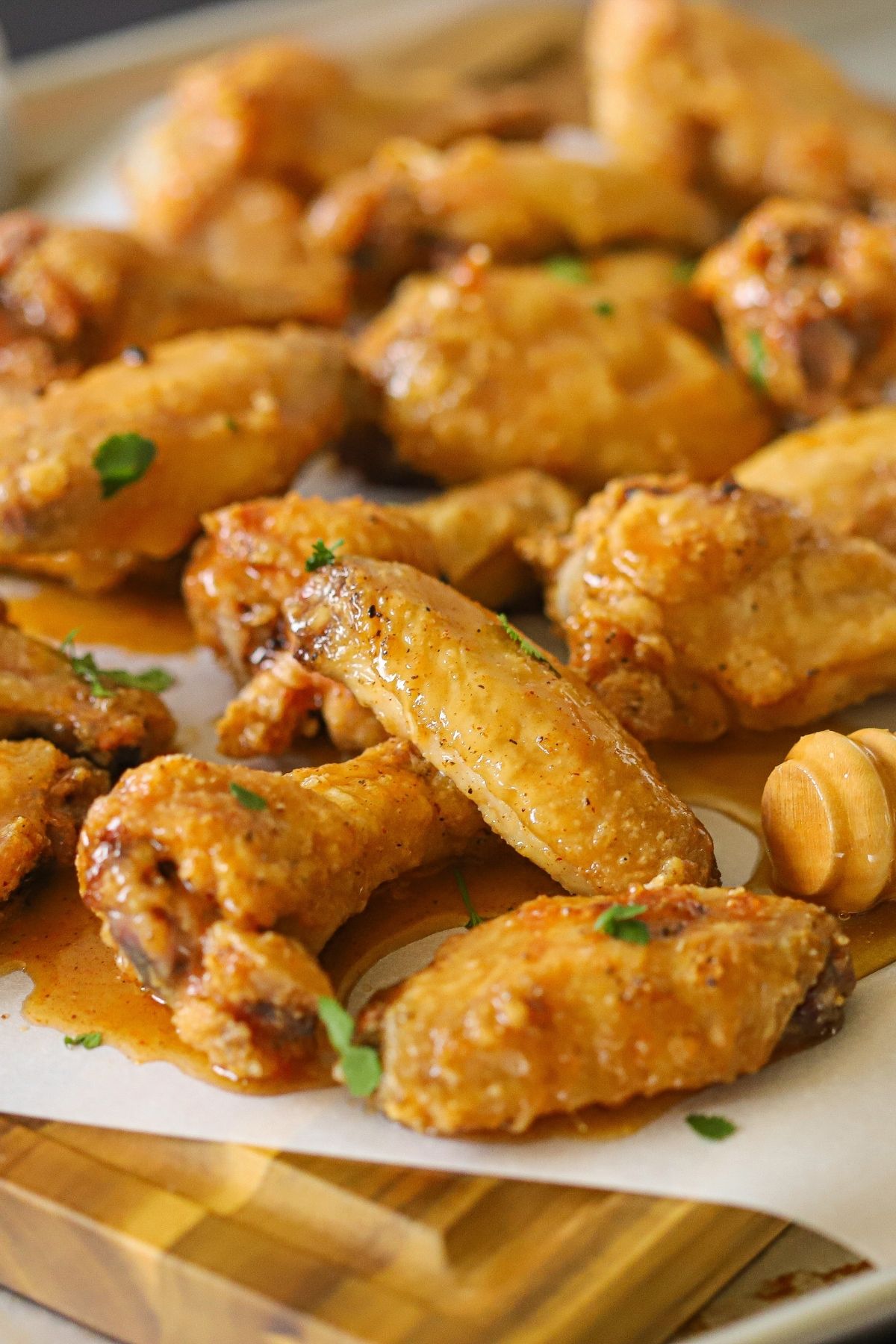 a pile of crispy chicken wings coated in a spicy honey sauce