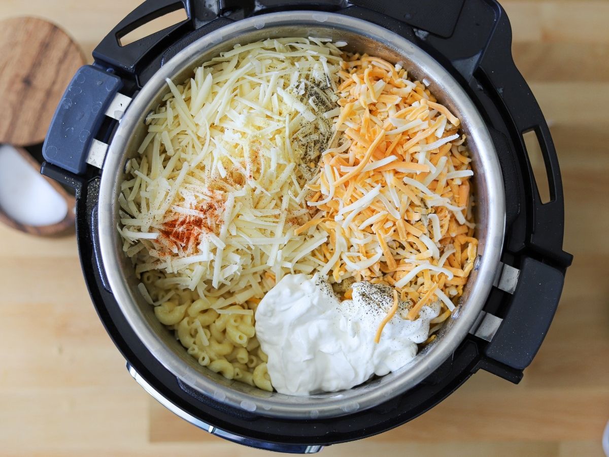 an instant pot full of cooked macaroni plus all the ingredients for homemade mac and cheese