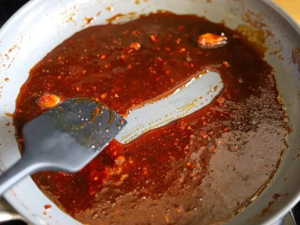An Asian glaze being cooked in a large skillet