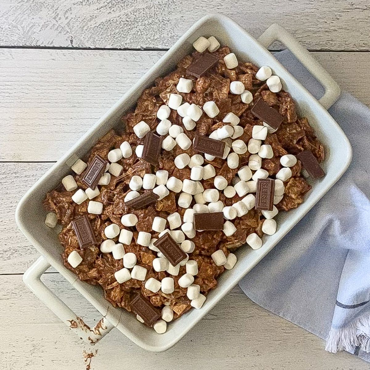 chocolate pieces and mini marshmallows sprinkled on top of s'more bars.