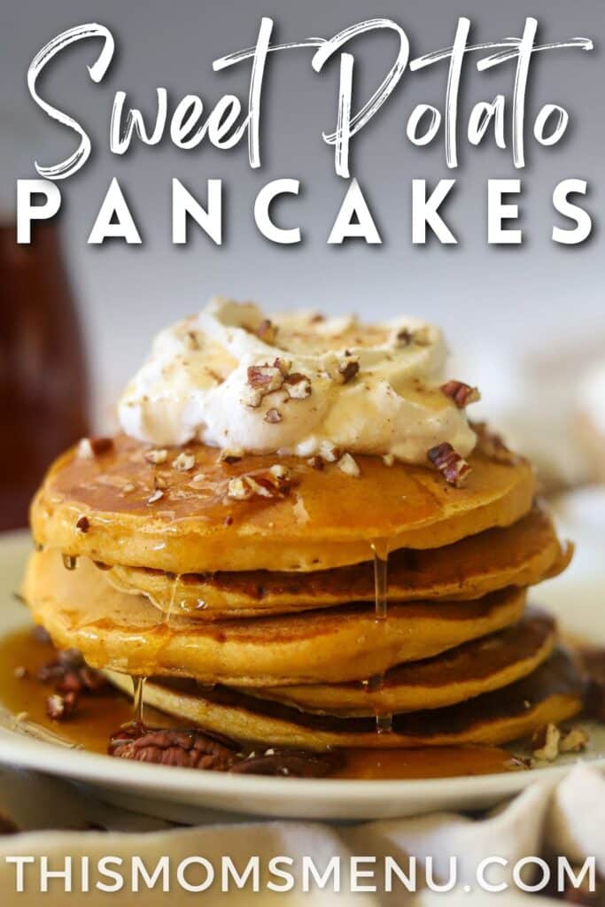 a stack of sweet potato pancakes on a white plate. They are topped with maple syrup, whipped cream, and chopped pecans.