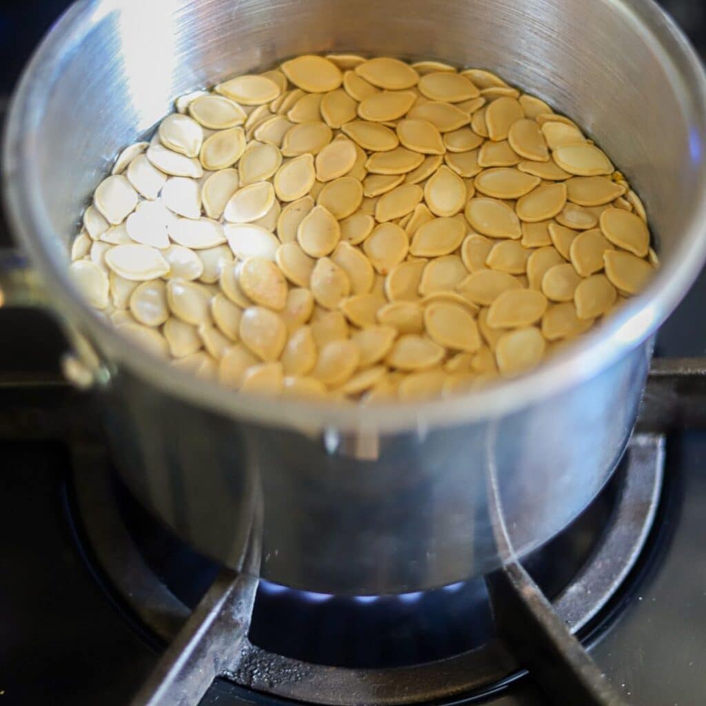 fresh pumpkin seeds in a large pot of water
