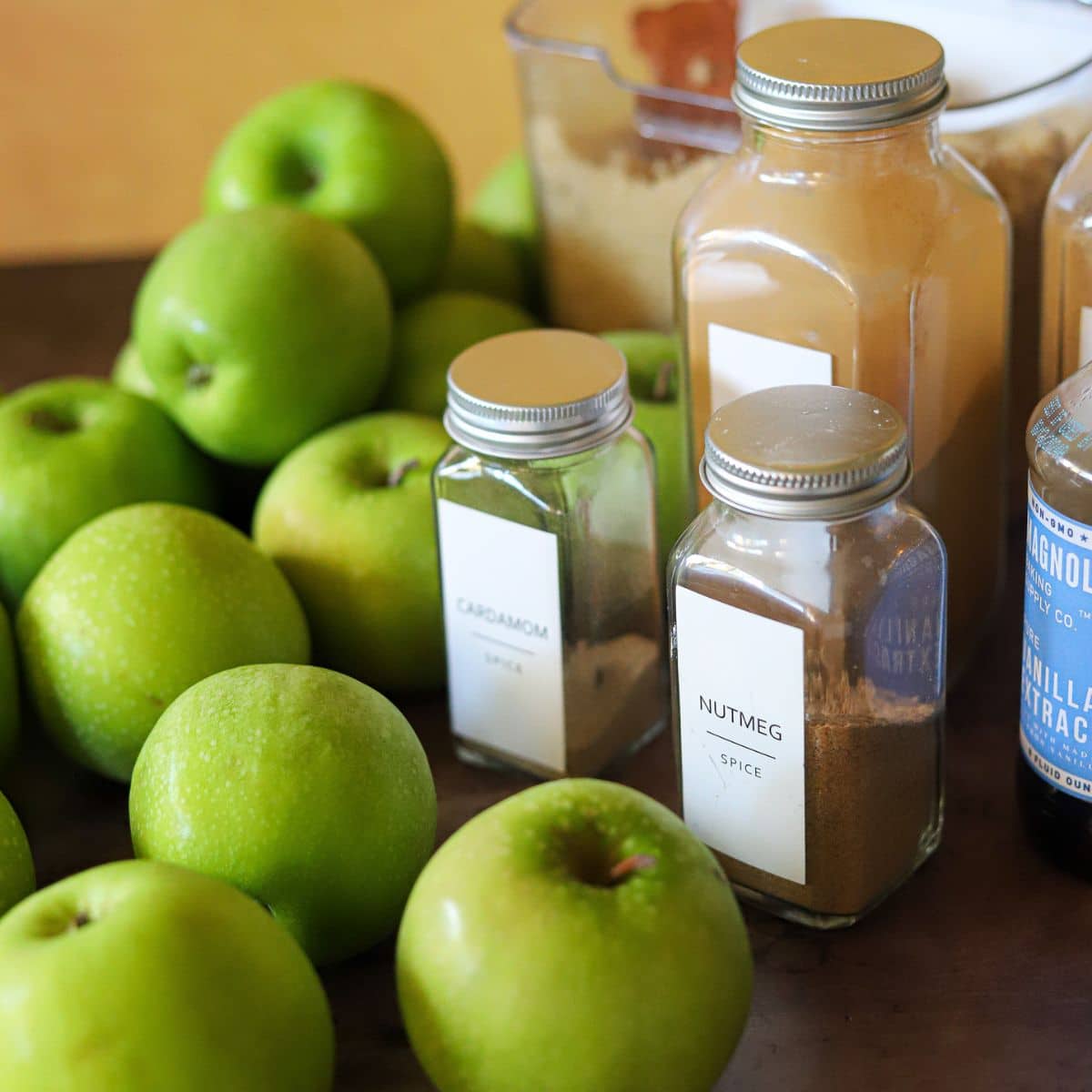 ingredients for homemade applesauce in the instant pot including apples, spices, brown sugar, and vanilla extract.