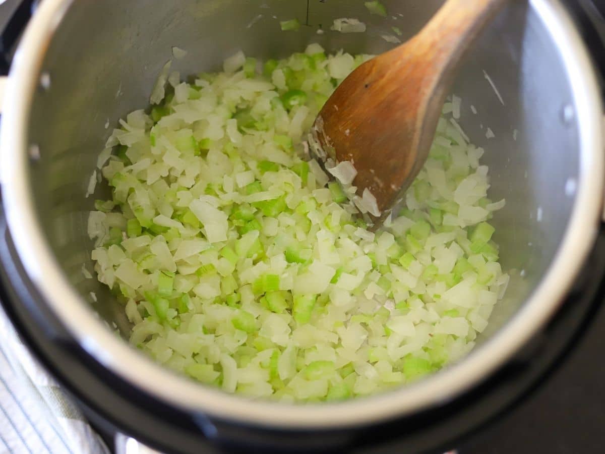 onions, celery, and garlic cooking in an instant pot