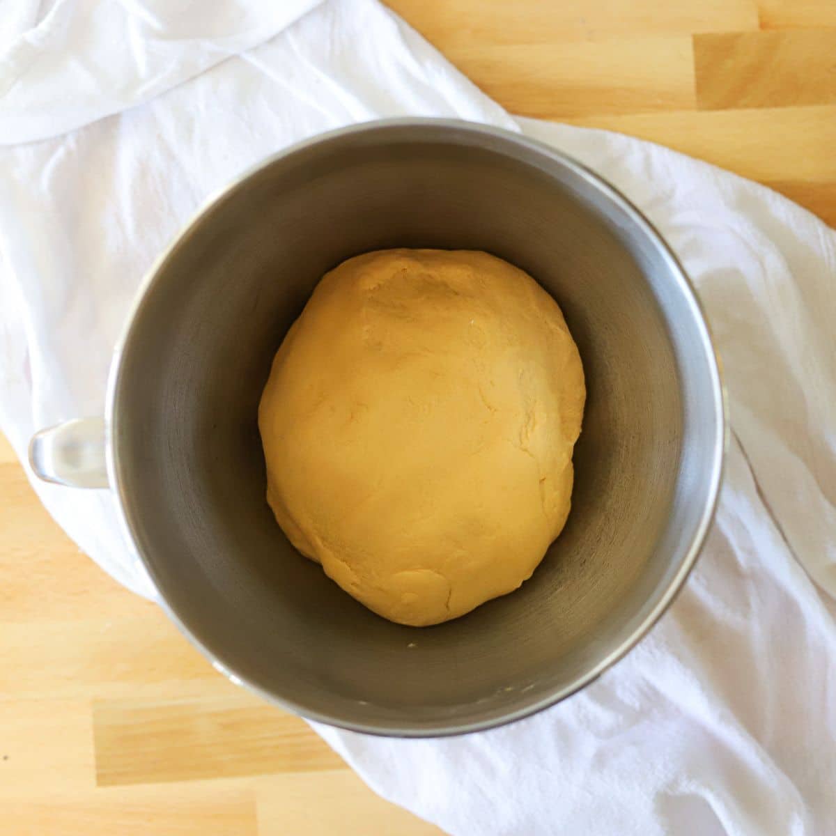 a ball of sweet potato dough in a silver bowl.