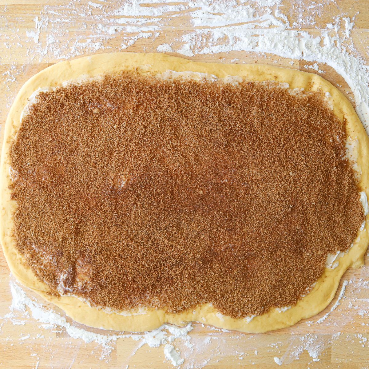 dough rolled out into a rectangle and coated in butter, brown sugar, and spices.