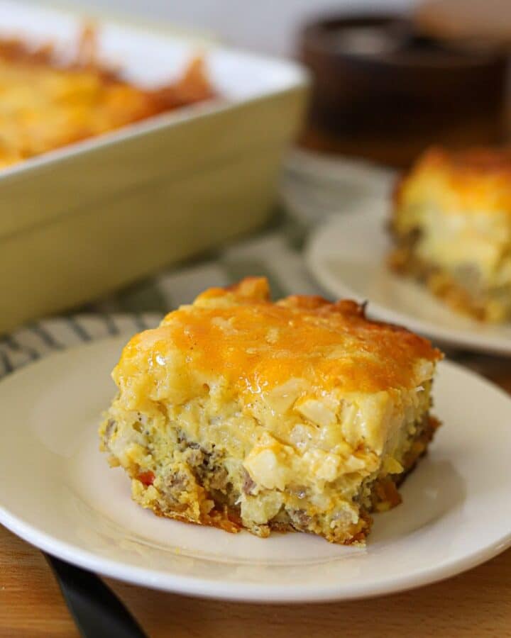 sausage egg and potato breakfast casserole served on white plates.