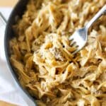 a fork full of creamy egg noodles and ground beef.