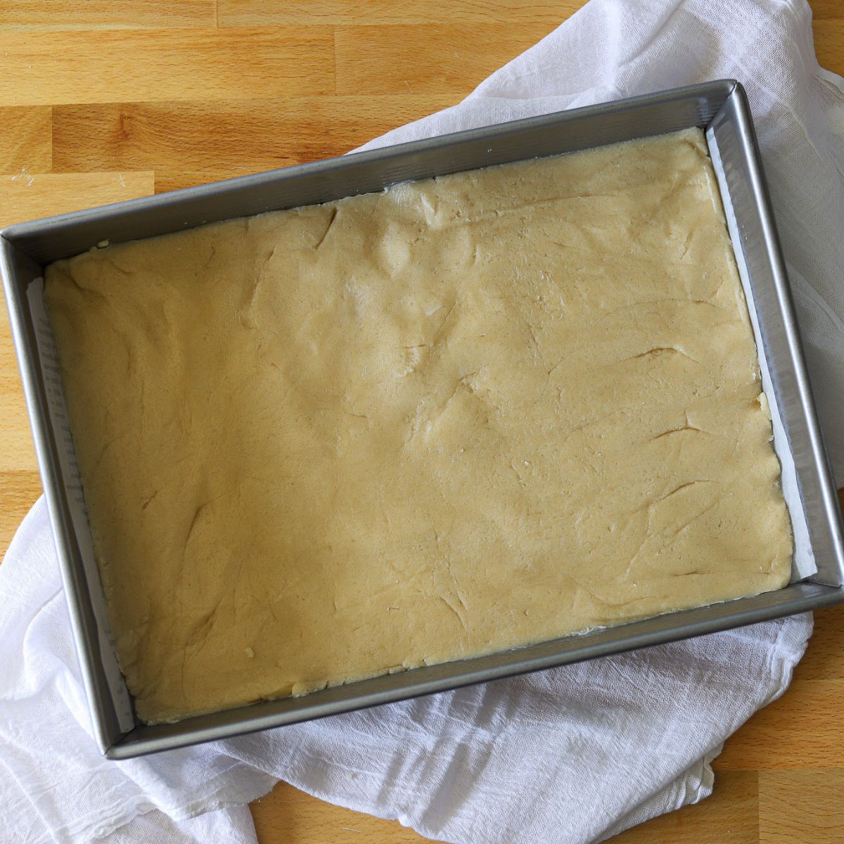 sugar cookie dough spread out in a baking pan.