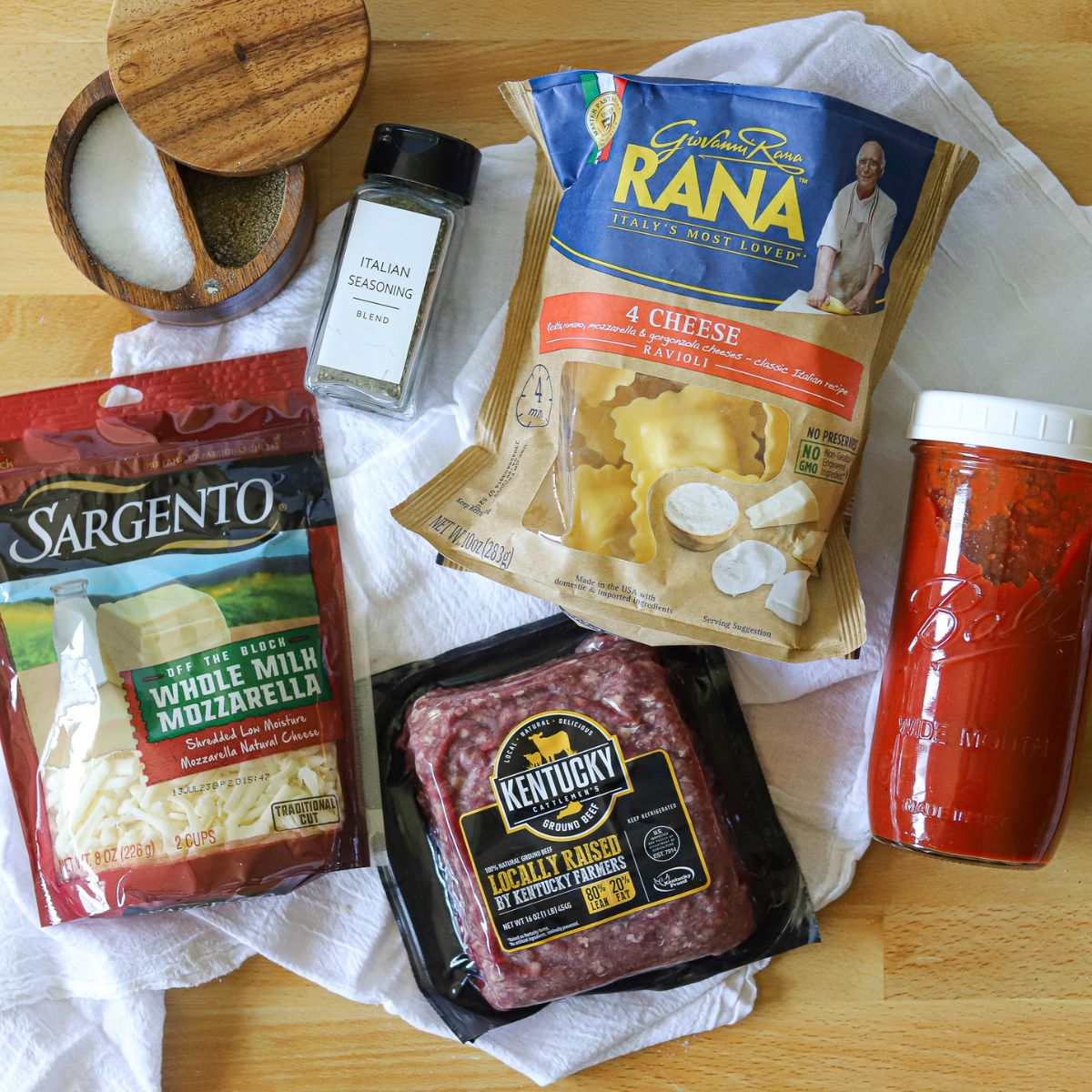 ingredients for lazy lasagna including ground beef, marinara sauce, ravioli, mozzarella cheese, italian seasoning, salt, and pepper