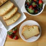 a sliced sour cream pound cake with fresh berries on the side