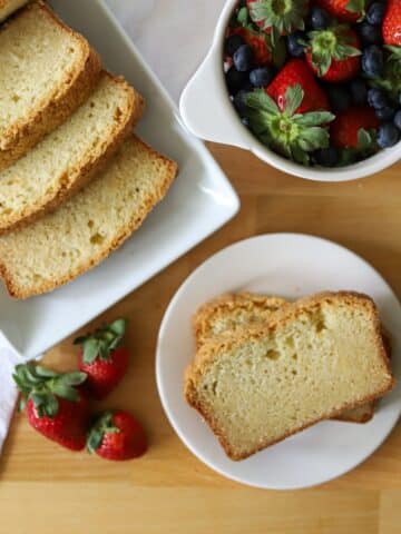 a sliced sour cream pound cake with fresh berries on the side