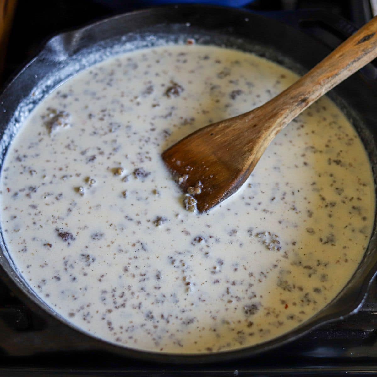 sausage breakfast gravy being cooked in a large skillet