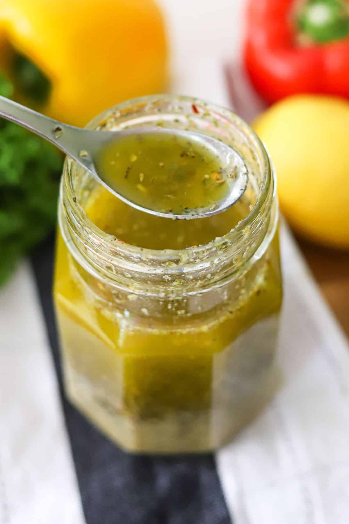 a glass jar filled with homemade Italian dressing.