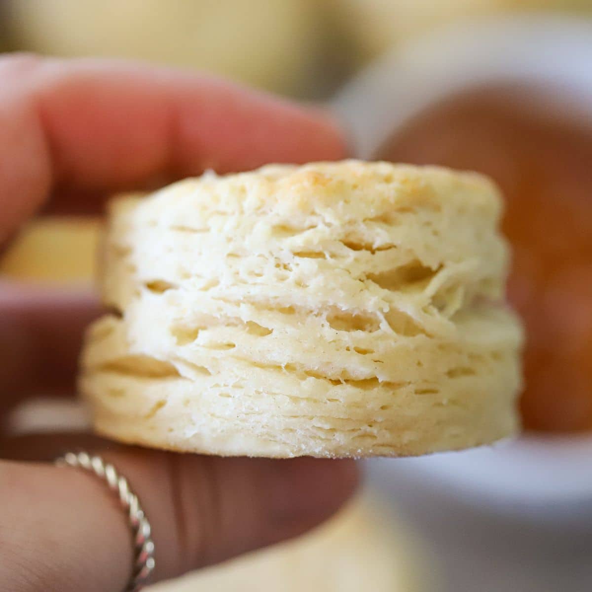 a homemade flakey biscuit being held up