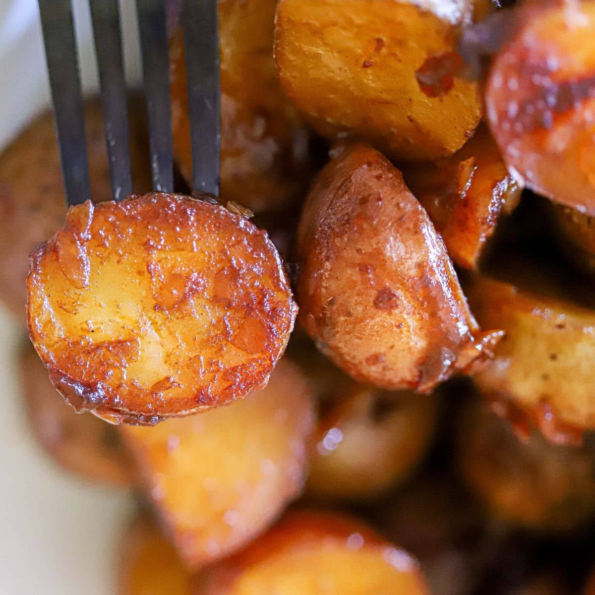 a close up of roasted potatoes on a fork