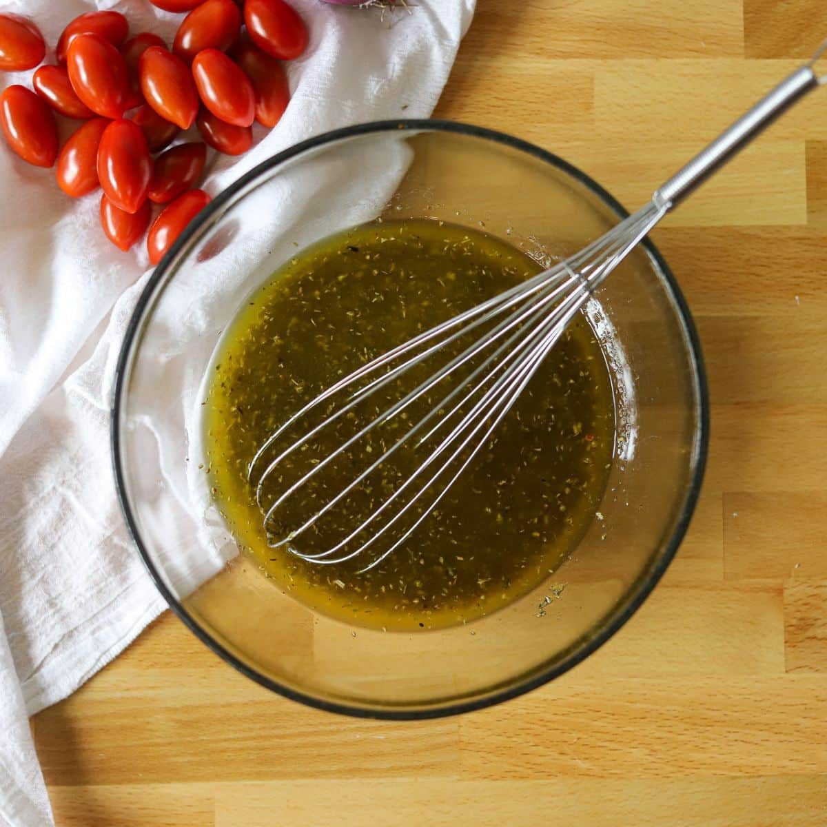 a small glass mixing bowl with homemade zesty italian dressing.