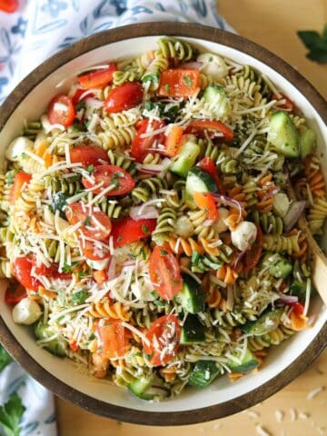 a bowl full of pasta salad made with tri color rotini and homemade zesty italian dressing