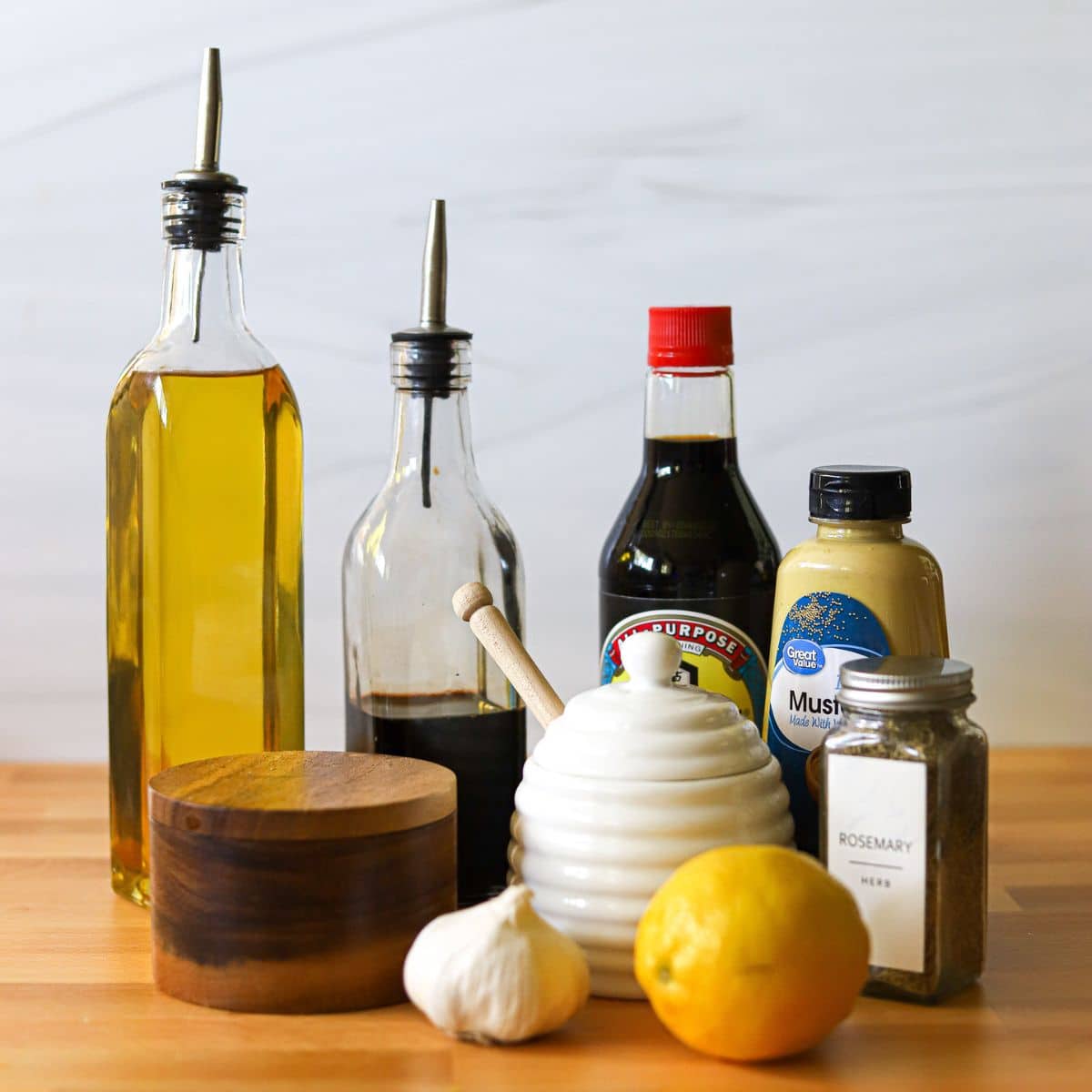 ingredients for a healthy chicken breast marinade including olive oil, balsamic vinegar, soy sauce, dijon mustard, honey, garlic, rosemary, lemon, and garlic.