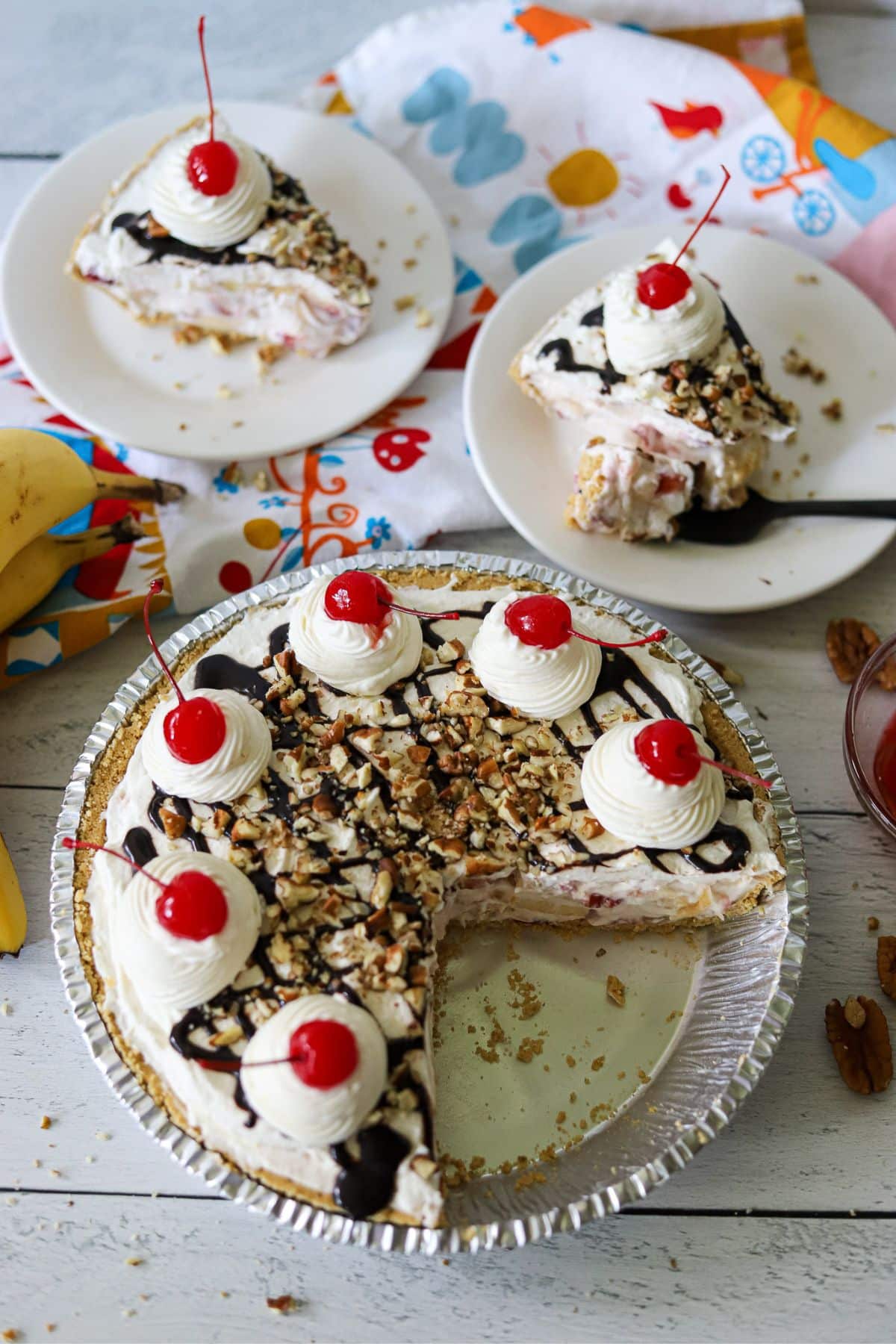 a banana split pie with two slices cut and on plates