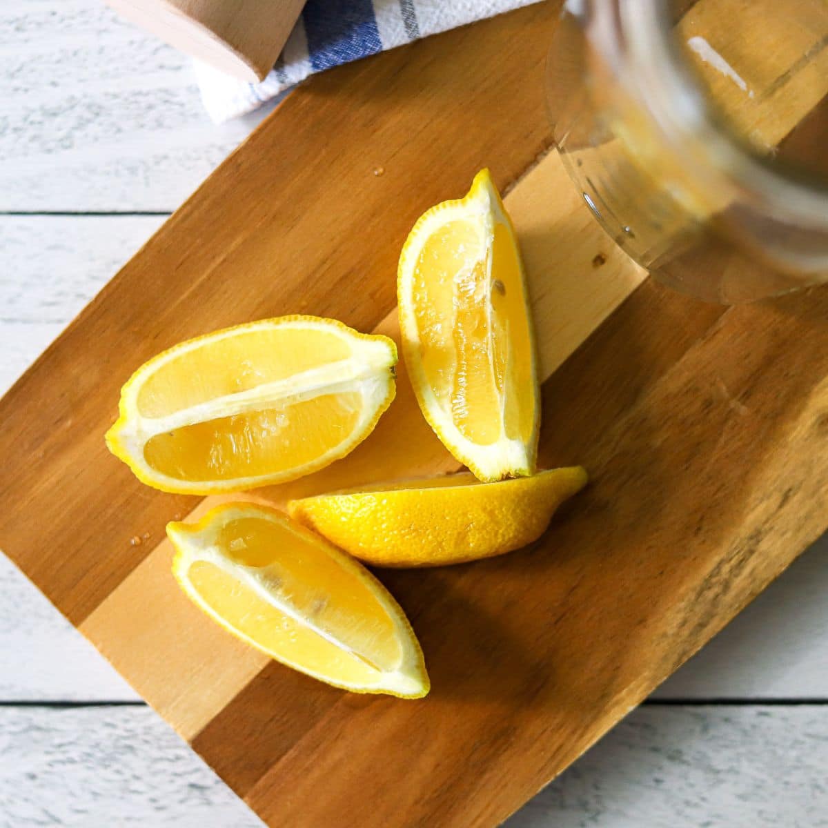 a lemon cut into wedges on a wooden cutting board